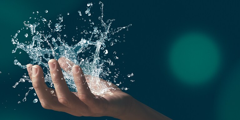 ​A hand holding water splashing out of it