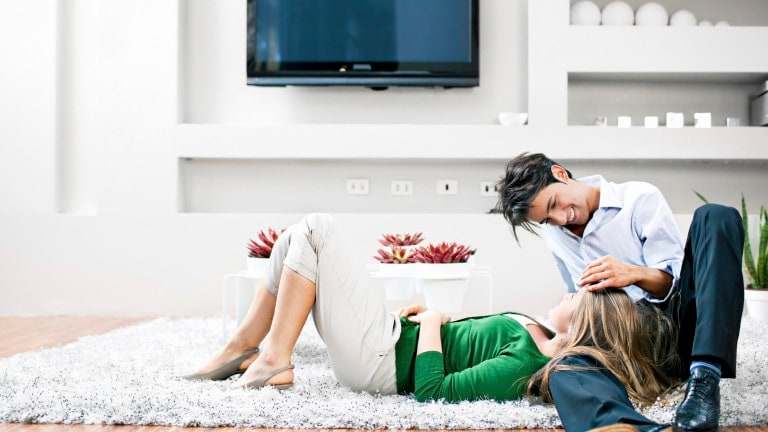 Couple in living room lying on the floor on a carpet