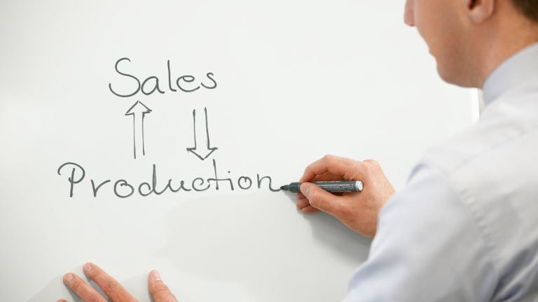 Man writes "Sales" and "Production" on a white board