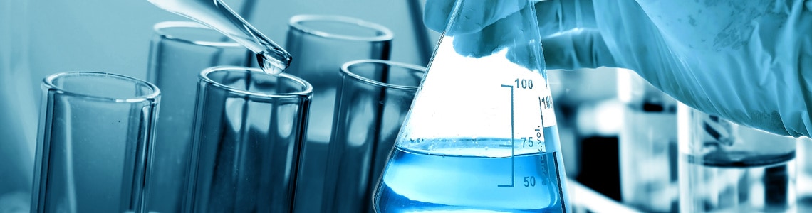 Flask in scientist hand with laboratory glassware background