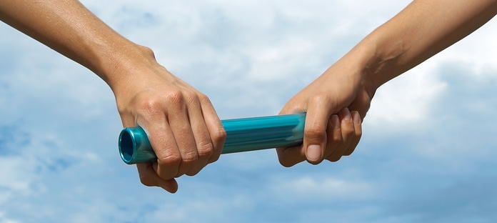 Two young women holding relay baton