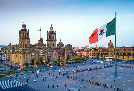 Die mexikanische Flagge weht über dem Zocalo, dem Hauptplatz von Mexiko-Stadt. Die Metropolitan-Kathedrale liegt gegenüber dem Platz, der auch als Platz der Verfassung bezeichnet wird.
