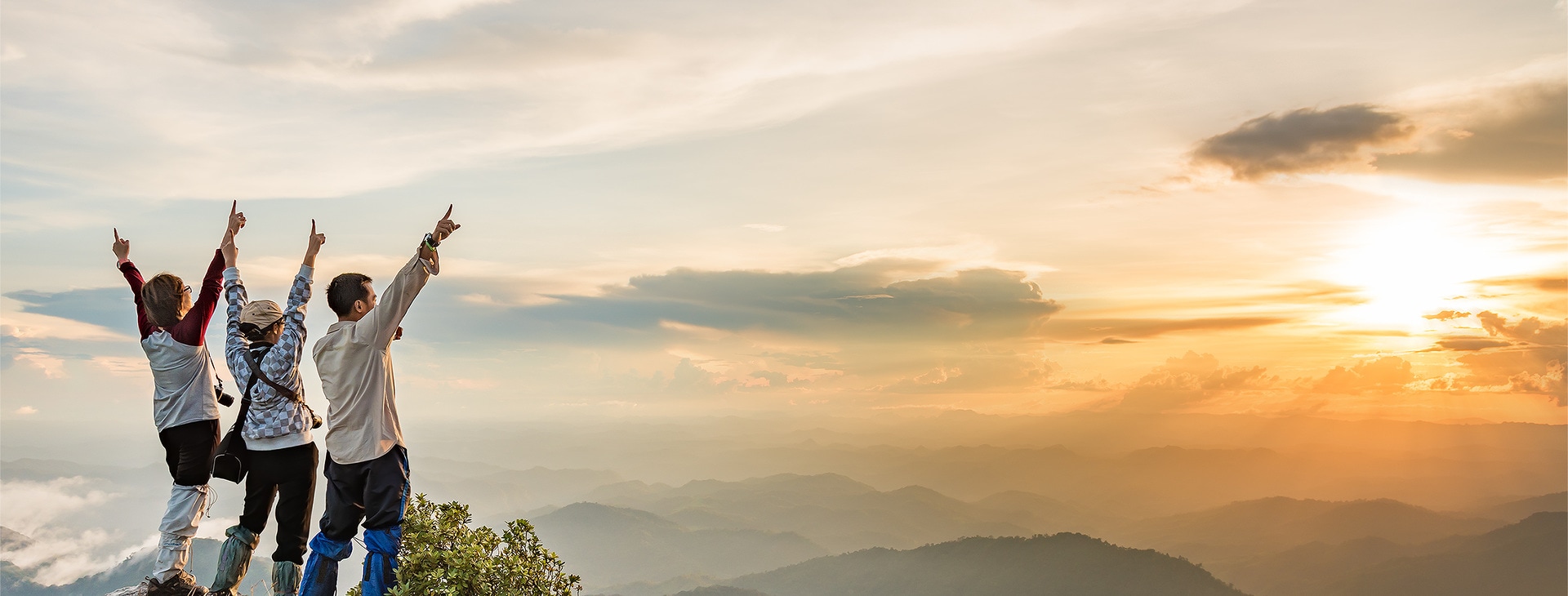 People standing on a hill with their hands in the air