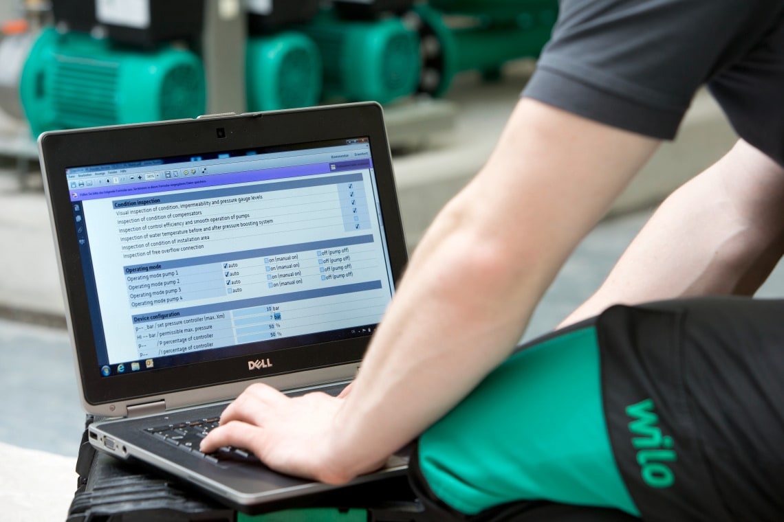 Service technician is sitting in front of a laptop