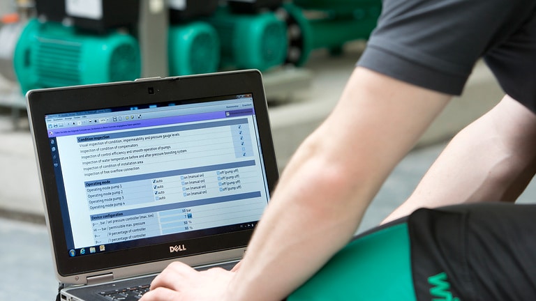 Service technician is sitting in front of a laptop