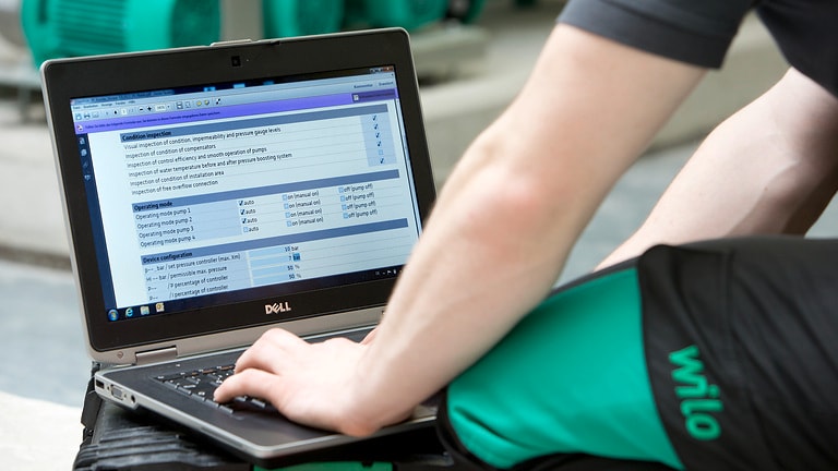 Service technician is sitting in front of a laptop