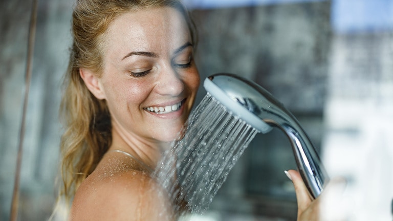 Frau duscht mit frischem Trinkwasser und optimiertem Wasserdruck.