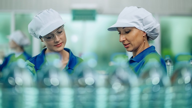 Moderne Produktionslinie in der Lebensmittelindustrie, auf der Wasserflaschen automatisch abgefüllt und verschlossen werden