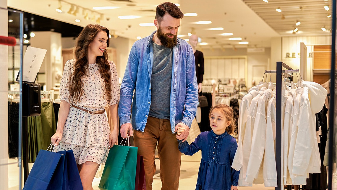 Des visiteurs font des achats dans un centre commercial moderne. L'environnement semble lumineux, accueillant et sûr. L'image évoque le confort, une expérience de shopping agréable et un sentiment de sécurité tant pour les visiteurs que pour les commerçants.