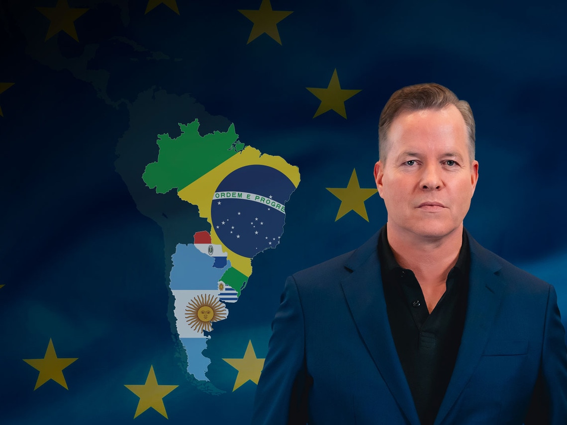 Oliver Hermes in front of the Mercosur states and a flag of Europe