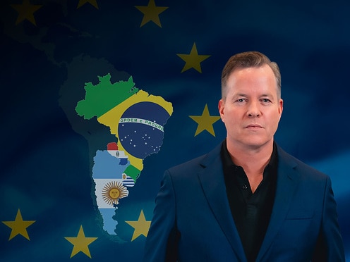 Oliver Hermes in front of the Mercosur states and a flag of Europe