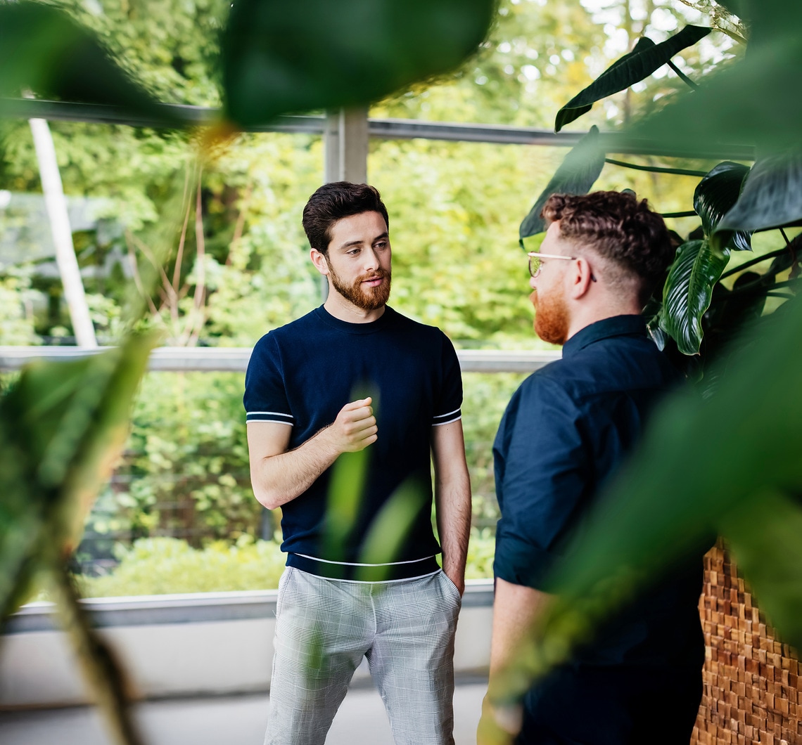 Fachlicher Austausch mehrerer Personen in einem Gebäudekomplex mit Bezug zu Gebäudetechnik und Energieverbrauch