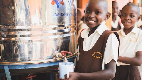 Glückliche Kinder an einem Wasserhahn